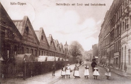 Um die Jahrhundertwende 1900: Die Niehler Straße mit den Werksgebäuden der Land- & Seekabelkwerke. Man beachte die Kinder und den reitenden Schutzmann.
